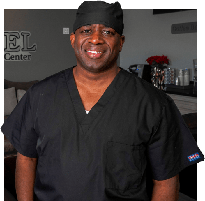 Dr. Samuel Collins, The Cowboy Dentist, smiling in professional attire at his clinic in Rosenberg & Manvel, TX