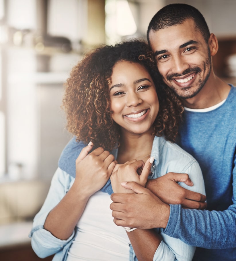 A young couple hugging over The Cowboy Dentist's new patient insurance plans